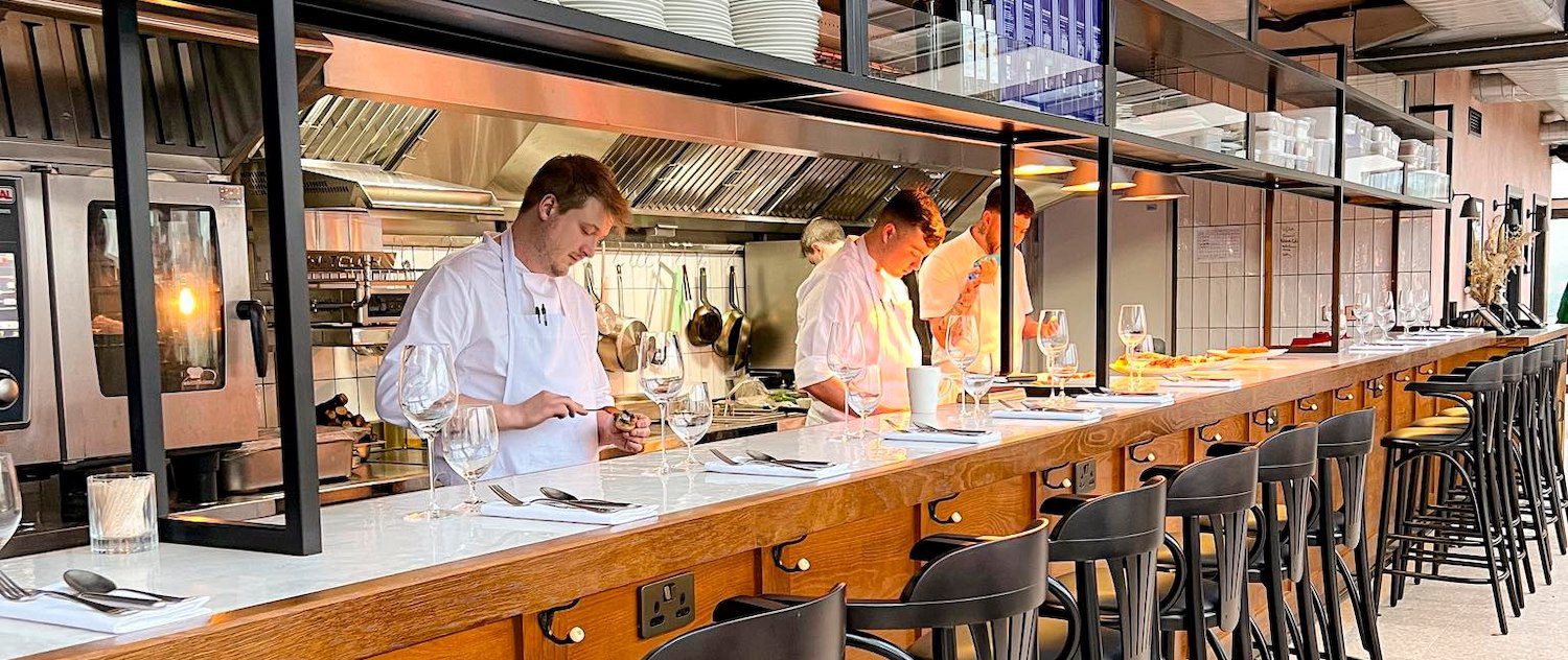 Climat restaurant bar with open kitchen and chefs working
